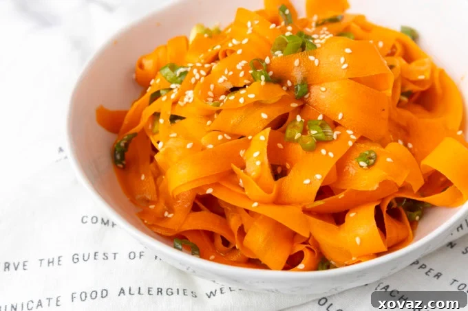 Another angle of the colorful Asian carrot ribbon salad in a white bowl