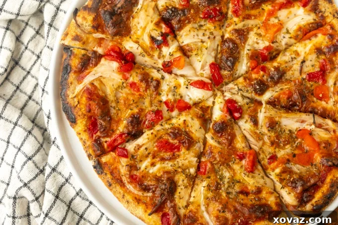 Close-up of tuna pizza with corn, olives, onions, and roasted red peppers