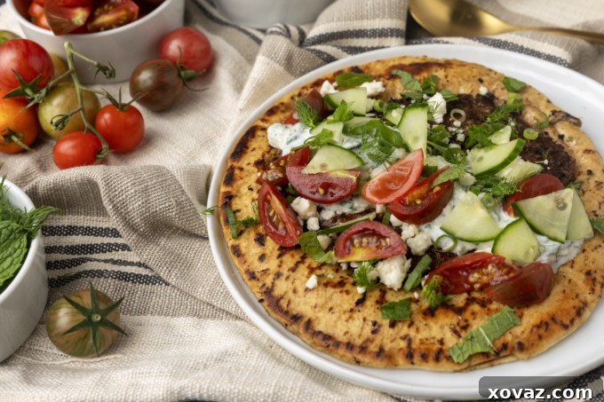 Delicious homemade gyro pita bread with seasoned lamb, fresh vegetables, and tzatziki sauce.