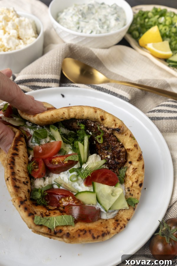 Finished gyro pita bread with abundant toppings, ready to eat.