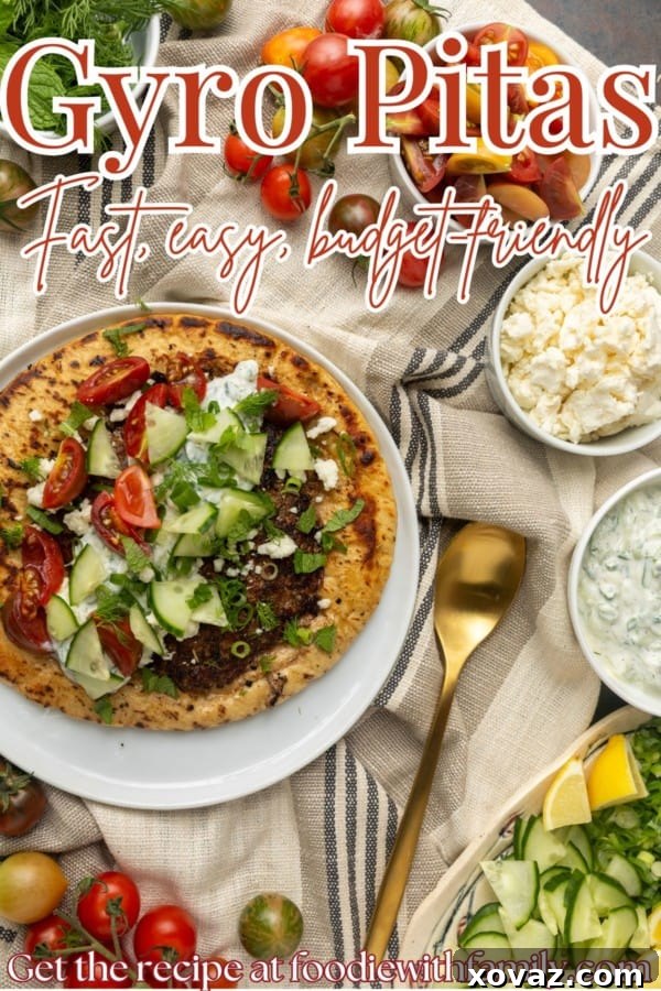 Overhead shot of two beautifully assembled gyro pita breads with lamb, tzatziki, and fresh vegetables.