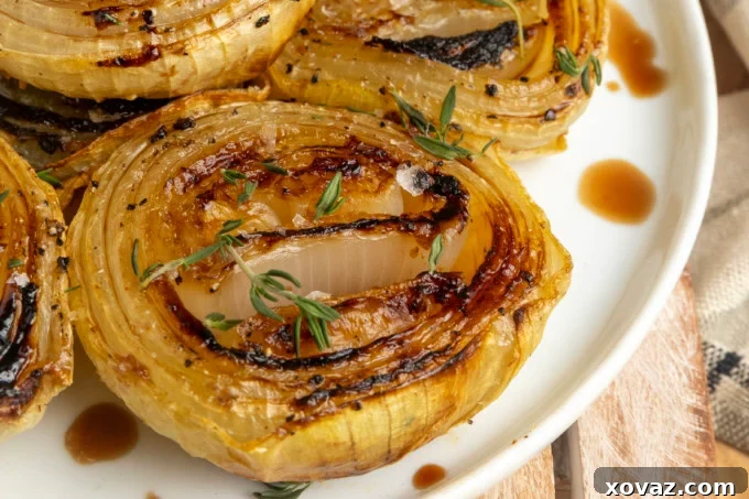 Close-up of perfectly baked onions glistening on a serving plate.