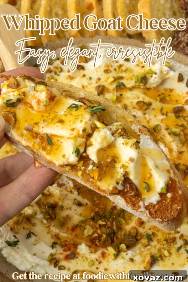 whipped goat cheese appetizer in a pottery bowl with crostini, salami, and grapes and text overlay describing the photo