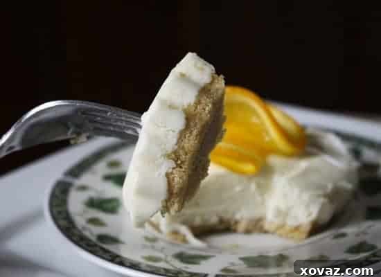 Orange Vanilla Creamsicle Cheesecake Delight Close-up of a perfectly portioned Orange Vanilla Creamsicle No-Bake Cheesecake