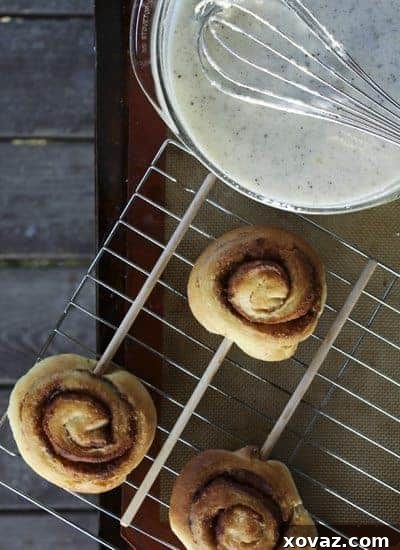 cinnamonrollonstick2 Several cinnamon rolls on sticks arranged neatly on a baking sheet, ready for baking.
