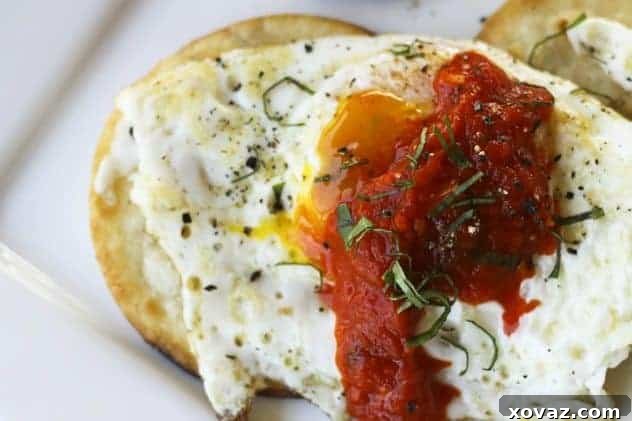 A plate with a fried egg topped with roasted red pepper spread and tortilla wedges.