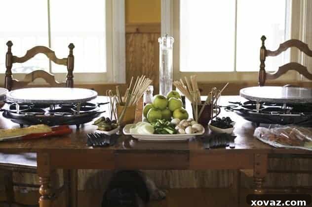 Spread of ingredients for a raclette dinner, including cheese, vegetables, and meats