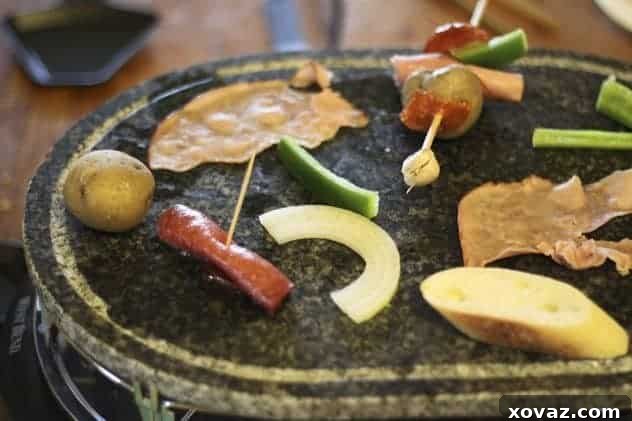 A raclette grill with various ingredients cooking and cheese melting