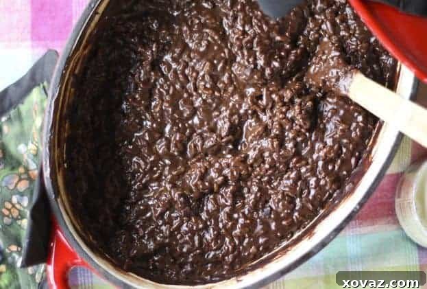 Delicious Champorado, a chocolate rice porridge, served in a bowl with a drizzle of milk.