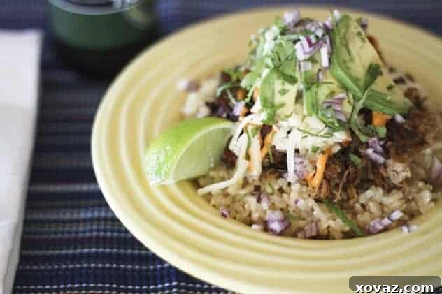 Delicious Slow-Cooker Cola Pulled Pork and Carnitas Rice Bowls, garnished with fresh cilantro and lime