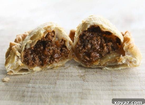 A close-up view of a cut Cincinnati Chili Empanada, revealing the rich, meaty chili filling