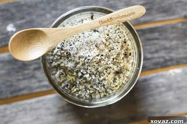 homemade lemon pepper seasoning jar A close-up shot of homemade lemon pepper seasoning being spooned into a glass jar, highlighting its fresh, vibrant texture.