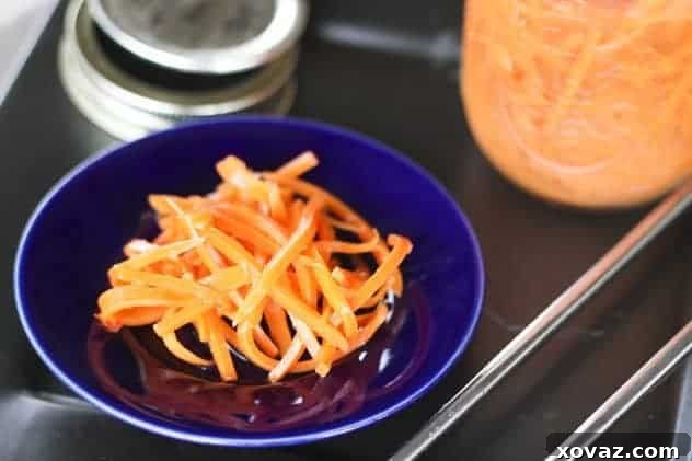 Two jars filled with sweet and spicy pickled carrots, ready for storage