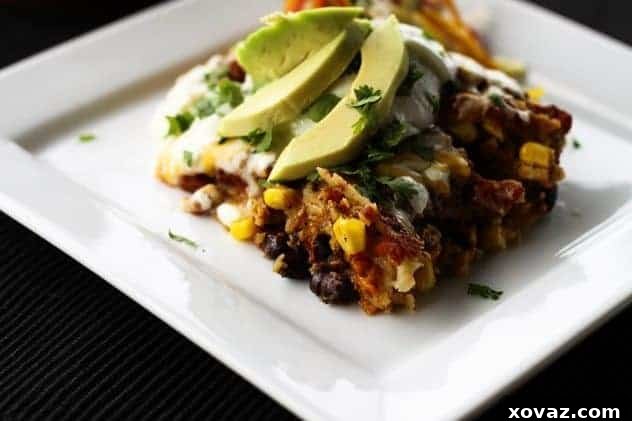 Hearty Slow-Cooked Chicken and Black Bean Enchiladas 2 Close-up of Slow Cooker Chicken and Black Bean Enchiladas topped with melted cheese, fresh cilantro, and a dollop of sour cream