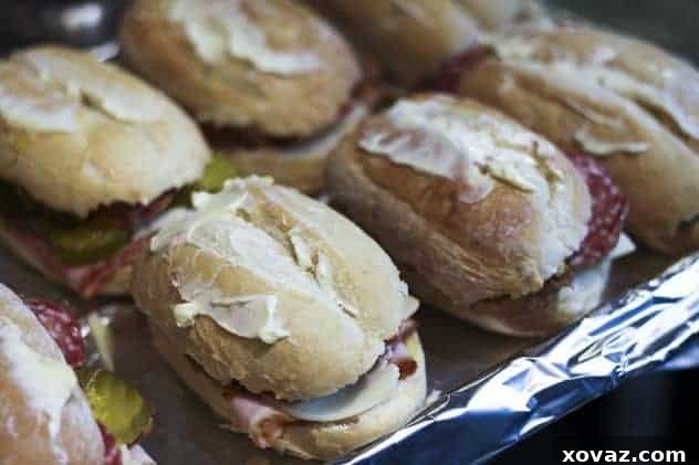 Cuban sandwiches arranged on a baking sheet, ready for pressing