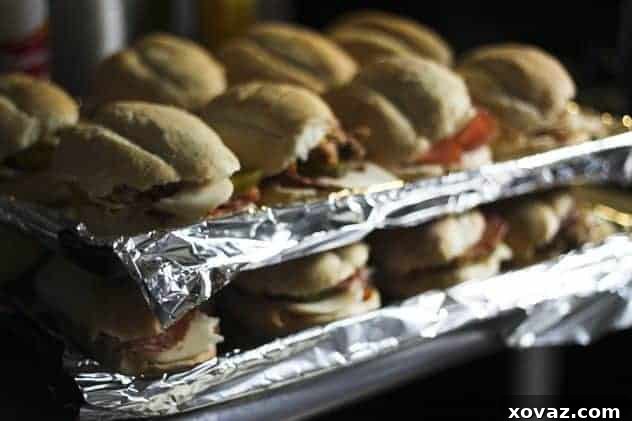 Cuban sandwiches being pressed between two baking sheets with heavy weights